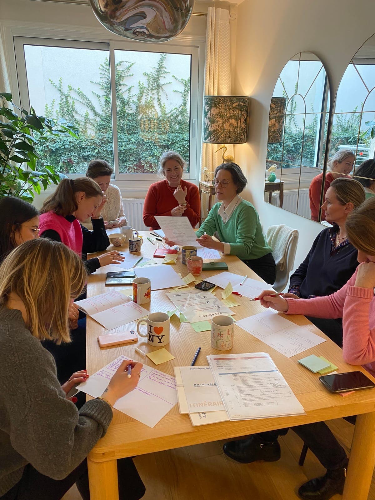Participantes attablées en atelier rêves, carnets et post-its étalés sur la table
